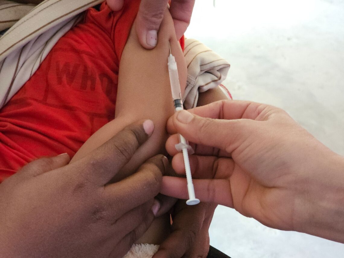 A child getting a vaccination shot administered by a healthcare professional