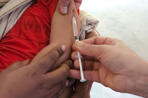 A child getting a vaccination shot administered by a healthcare professional