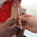 A child getting a vaccination shot administered by a healthcare professional