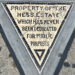 Il piccolo triangolo di mosaico del Hess Triangle incastonato nel marciapiede all'angolo tra Christopher Street e Seventh Avenue a Greenwich Village
