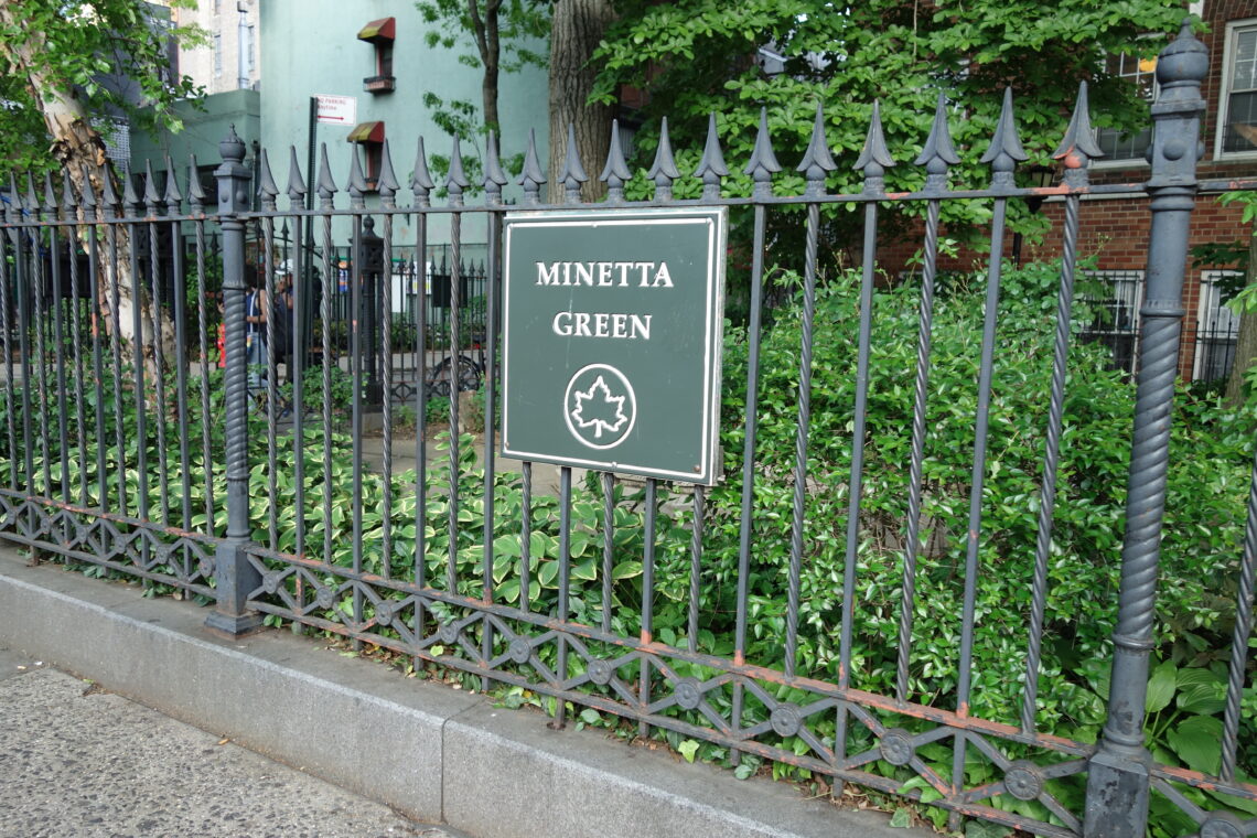 Un piccolo parco recintato con aiuole verdi e alberi, il Minetta Green, in una stradina del Greenwich Village a New York